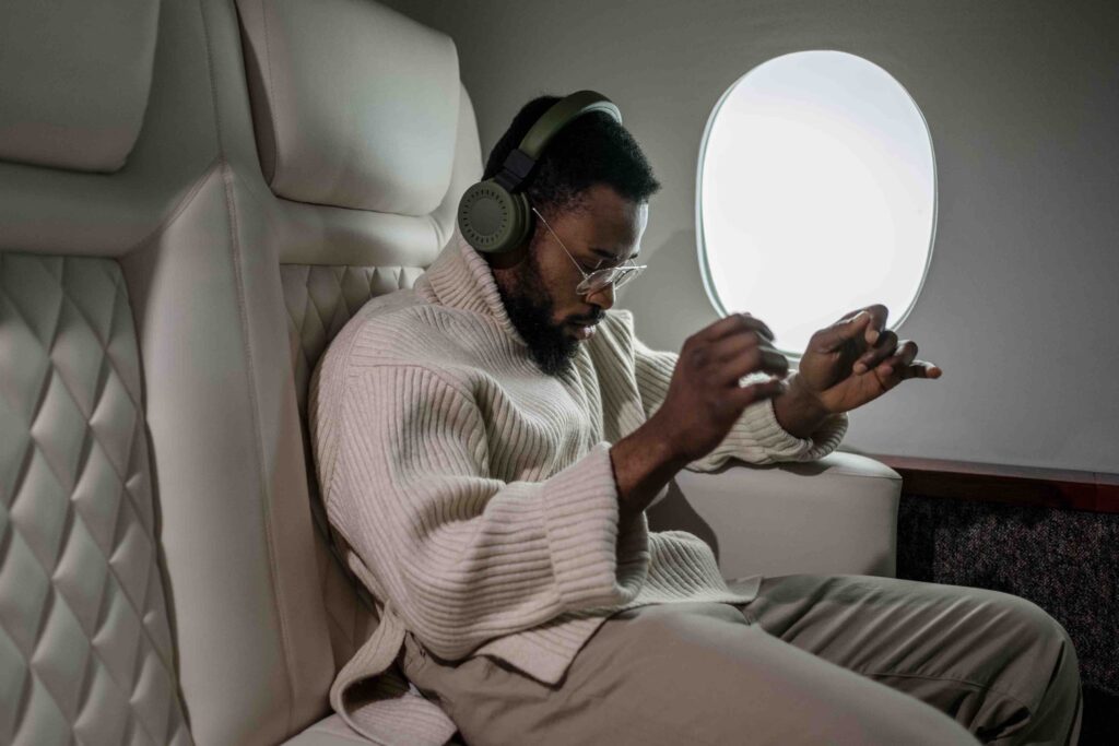 Man Lying Down Inside a Airplane and Listening to Musi